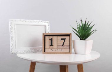 17 Ekim tarihli ahşap takvim düzenleyici ve masanın üzerinde fotoğraf çerçevesi