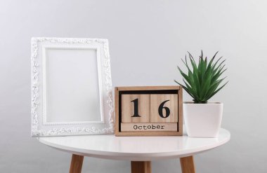 Tahta takvim düzenleyicisi. Tarih 16 Ekim ve fotoğraf çerçeveli.