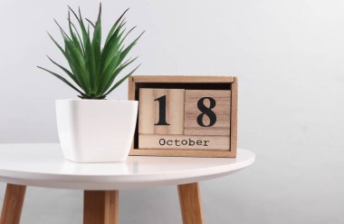 18 Ekim tarihli ahşap takvim düzenleyici ve masanın üzerinde fotoğraf çerçevesi