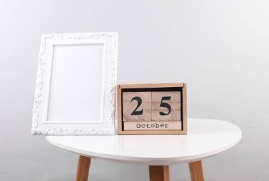 Ahşap takvim düzenleyicisi. 25 Ekim ve fotoğraf çerçeveli.