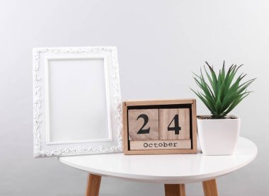 24 Ekim tarihli ahşap takvim düzenleyici ve masa üzerinde fotoğraf çerçevesi