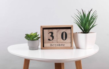 30 Ekim tarihli ahşap takvim düzenleyici ve masa üzerinde dekoratif bitkiler