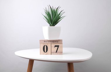 7 Kasım tarihli ahşap takvim düzenleyici ve masa üzerinde dekoratif bitki