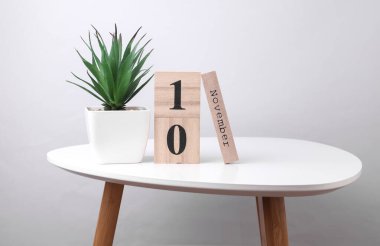 10 Kasım tarihli ahşap takvim düzenleyici ve masa üzerinde dekoratif bitki
