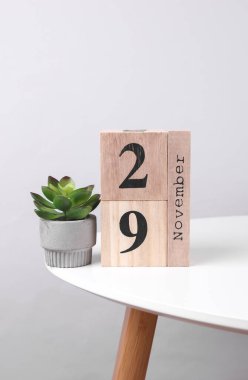 29 Kasım tarihli ahşap takvim düzenleyici ve masa üzerinde dekoratif bitki