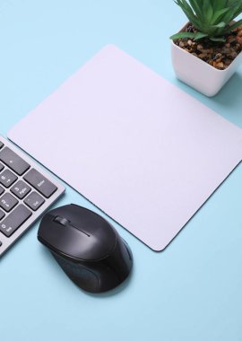 Mavi arkaplanda fare, fare ve klavye bulunan beyaz, boş bilgisayar fare altlığının bir kopyası. Üst Manzara. Düz yatıyordu