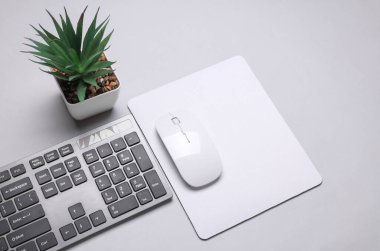 Gri arkaplanı fare, fare ve klavye olan beyaz, boş bilgisayar fare altlığının bir kopyası. Üst Manzara. Düz yatıyordu