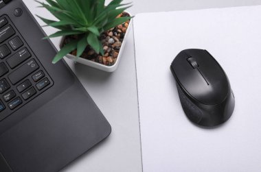 Gri arka planda beyaz, boş bilgisayar fare altlığı ya da aksesuarlı, fare ve dizüstü bilgisayarın bir kopyası. Üst Manzara. Düz yatıyordu