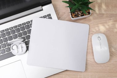 Masanın üzerinde aksesuar, fare, kulaklık ve dizüstü bilgisayarı olan boş bilgisayar fare altlığı ya da minderin bir kopyası. Modern aletler. Üst Manzara. Düz yatıyordu