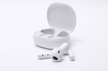 Beyaz kablosuz kulaklık ve şarj kutusu beyaz arkaplanda izole