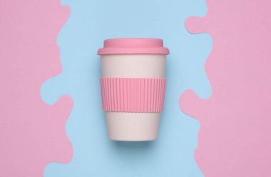 Mavi arka planda sıcak içecekler için yeniden kullanılabilir plastik bardak