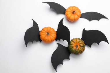 Beyaz arka planda yarasa kanatları olan balkabakları. Cadılar Bayramı el yapımı dekor