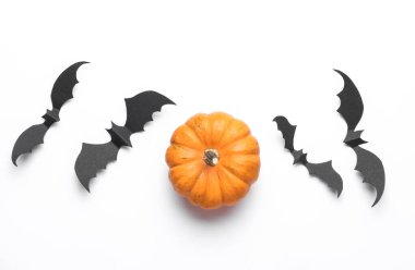 Paper cut black bats and pumpkin on white background. Halloween decor