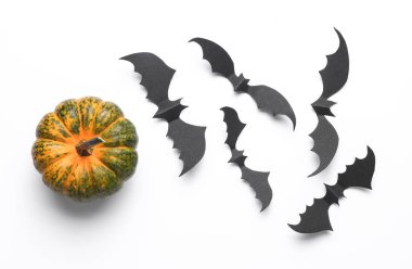 Kağıt, beyaz arka planda siyah yarasalar ve balkabağı kesiyor. Cadılar Bayramı Dekorasyonu