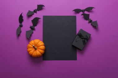 Mor arka planda siyah kartı olan cadılar bayramı dekoru. Üst Manzara. Düz yatıyordu