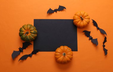 Turuncu arka planda siyah kart olan cadılar bayramı dekoru. Üst Manzara. Düz yatıyordu