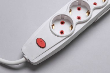 Gri arkaplanda güç düğmesi olan beyaz elektrik uzatma kablosu
