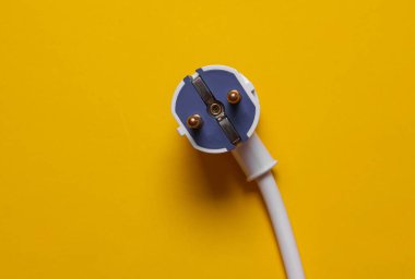 Sarı arka planda kablolu elektrik prizi