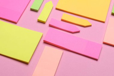 Çeşitli boş kağıt çıkartmaları var. Çok renkli. Mavi arkaplanda yapışkan not koleksiyonu