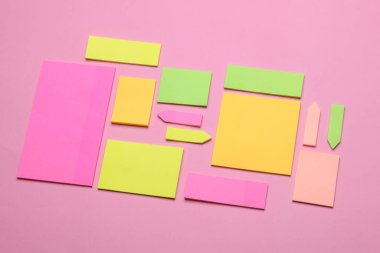 Çeşitli boş kağıt çıkartmaları var. Çok renkli. Mavi arkaplanda yapışkan not koleksiyonu