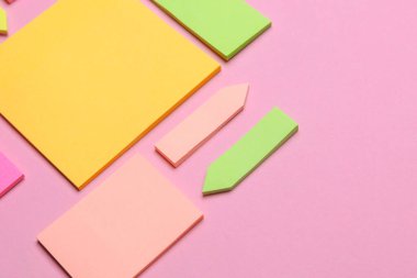 Çeşitli boş kağıt çıkartmaları var. Çok renkli. Mavi arkaplanda yapışkan not koleksiyonu