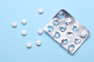 Mavi arka planda su toplayan beyaz haplar