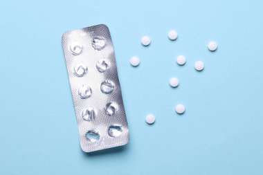 Mavi arka planda su toplayan beyaz haplar.