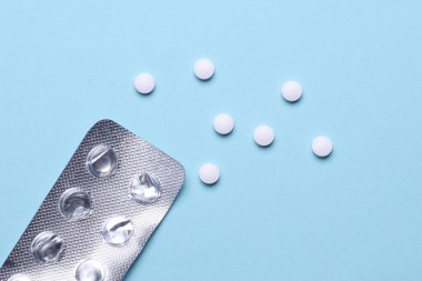 Mavi arka planda su toplayan beyaz haplar.