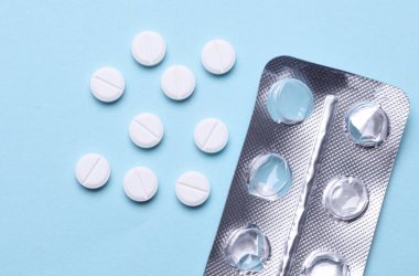 Mavi arka planda su toplayan beyaz haplar.