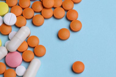 Mavi arka planda bir sürü farklı hap.