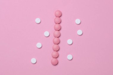 Pastel arka planda bir grup pembe ve mavi hap.