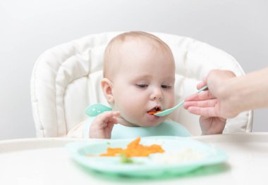 Annem bebeği kaşıkla besliyor.