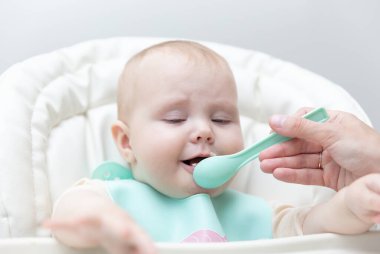 Annem bebeği kaşıkla besliyor.