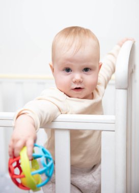 Sevimli bebek beşiğinde çıngırakla oynuyor