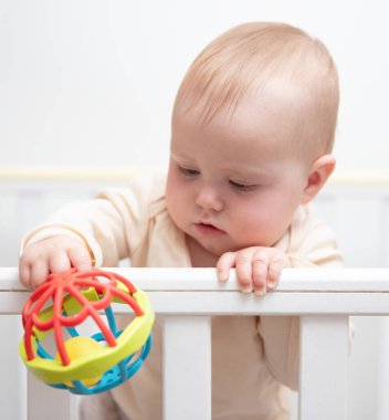 Sevimli bebek beşiğinde çıngırakla oynuyor