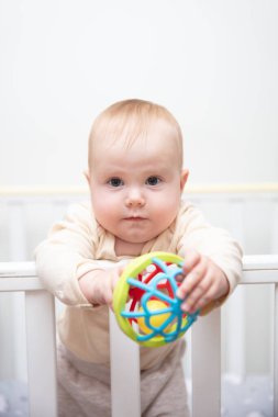 Sevimli bebek beşiğinde çıngırakla oynuyor