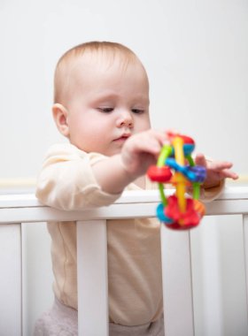 Sevimli bebek beşiğinde çıngırakla oynuyor