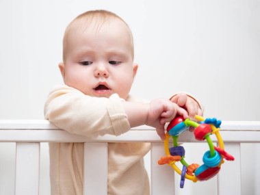 Sevimli bebek beşiğinde çıngırakla oynuyor