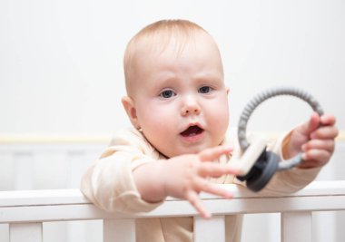 Sevimli bebek beşiğinde çıngırakla oynuyor