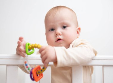 Sevimli bebek beşiğinde çıngırakla oynuyor