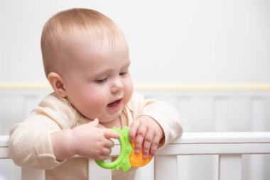 Sevimli bebek beşiğinde çıngırakla oynuyor