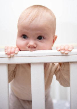 Beşikteki şirin bebek yan tarafını kemiriyor.