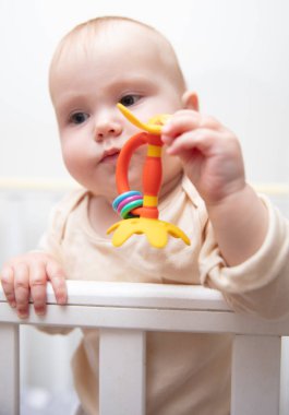 Sevimli bebek beşiğinde çıngırakla oynuyor