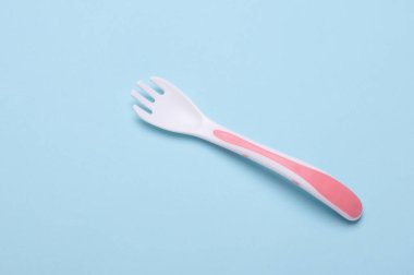 Mavi arka planda bebek beslemek için plastik çatal