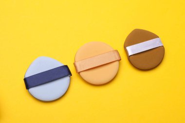 Makyaj süngeri sarı arka planda blenderları süngerler. Güzellik konsepti