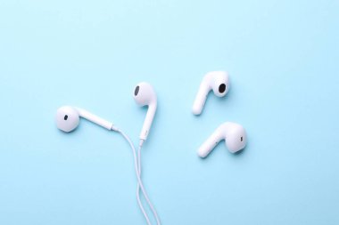 Kablolu ve telli beyaz kulaklıklar mavi arka planda