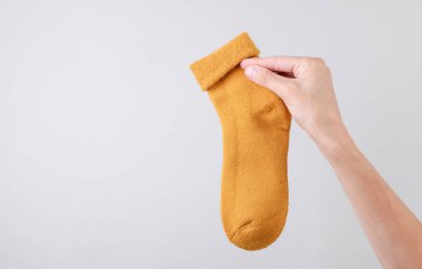 Gri arka planda çorap tutan kadın.