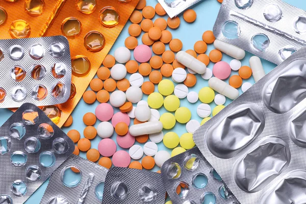 Mavi arka planda bir sürü farklı hap ve su topladı.
