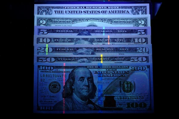 Billetes de dólar en luz ultravioleta . —  Fotos de Stock