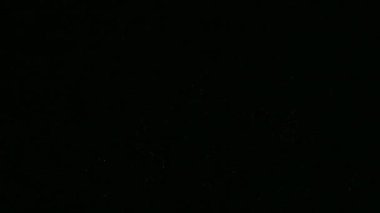 Kasvetli gece gökyüzünde parlayan 4k 'lık altın havai fişek videosu